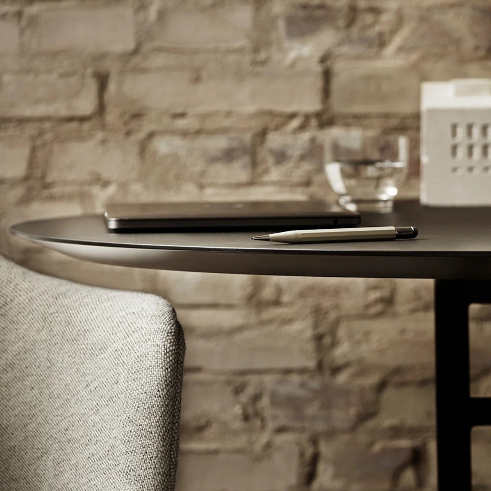 Snaregade Table in oval shape with a laptop and pen against a stone wall