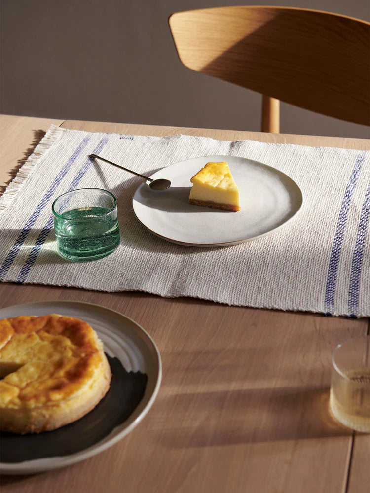 Flow Plate Off-White Speckle plate in size medium on dining table — minimal Scandinavian tableware.