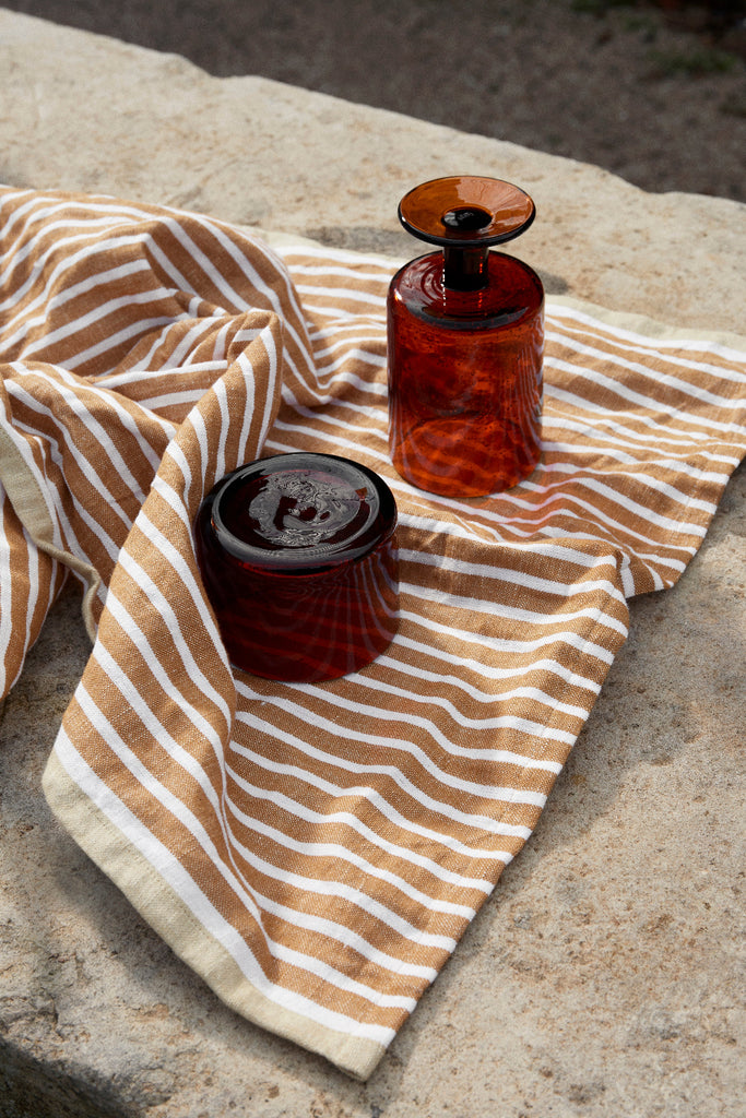 Hale Tea Towel by Ferm Living in Golden Brown and Silver Fern show with glassware.