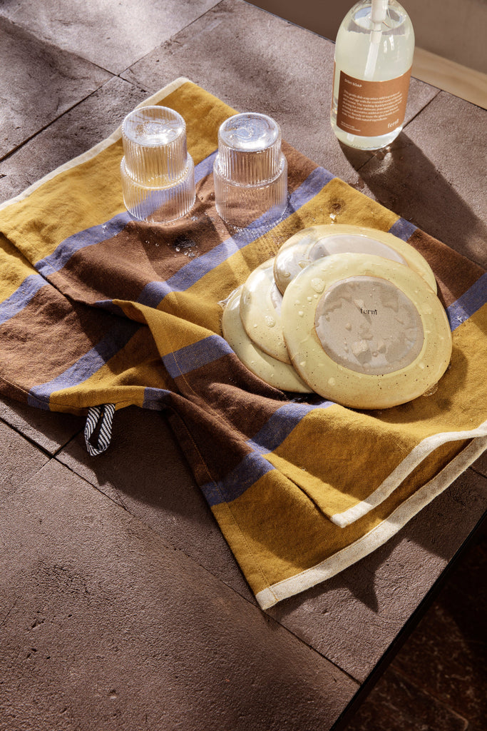 Lifestyle image of Ferm Living Hale Tea Towel in Lime / Bright Blue / Choco showing in a modern kitchen with Ripple Glassware