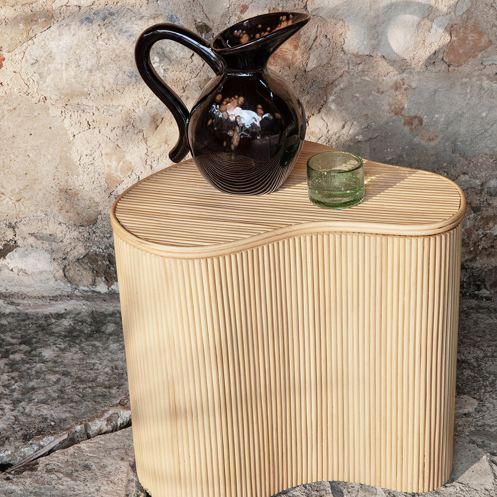 Isola Storage Table as a side table with pitcher and glass.