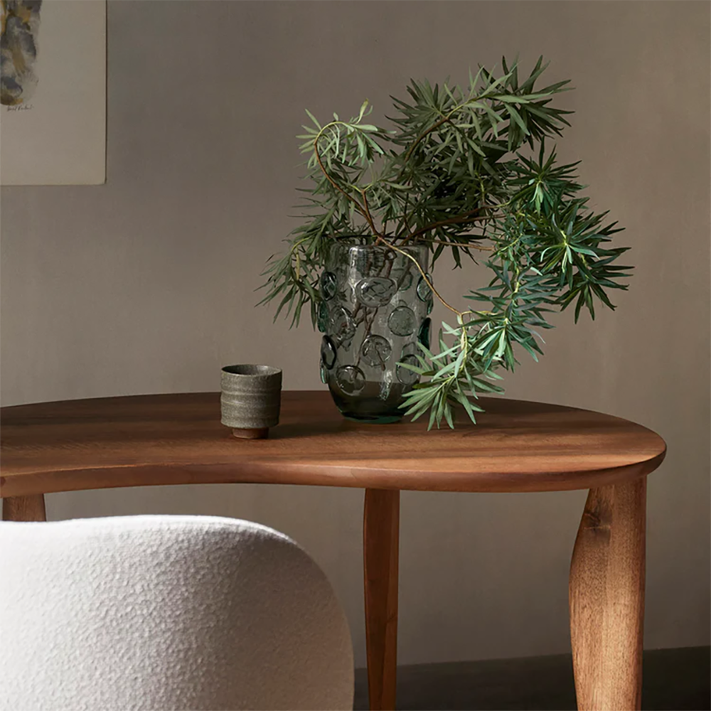 Lump Vase in Green holding a loose bouquet on a console, sculptural dotted glass