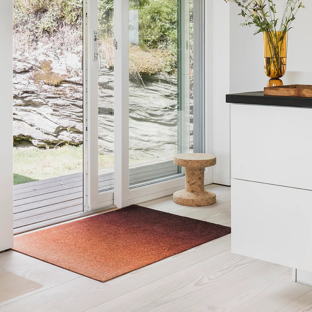 Dis Rust ombré doormat in earthy tones, styled bright Scandinavian entryway with white washed wood floors.