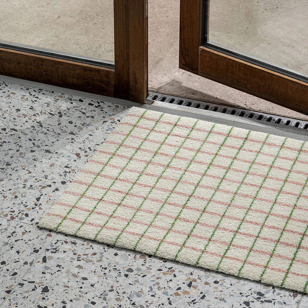 Heymat Grid Lime Candycane doormat with square grid design, styled in modern entryway on terrazzo floor with natural elements.