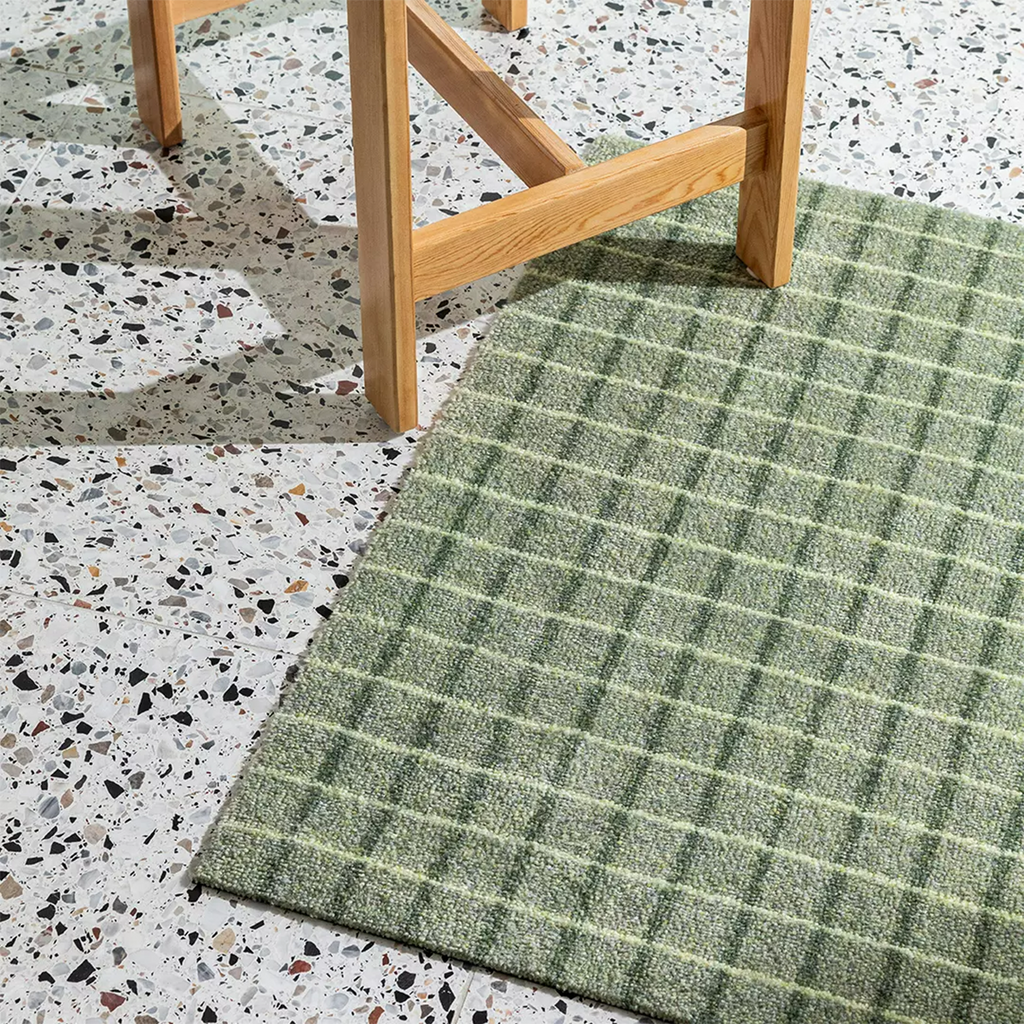 Heymat Grid in color Matcha Lemon washable slip-resistant doormat on modern terrazzo floor.