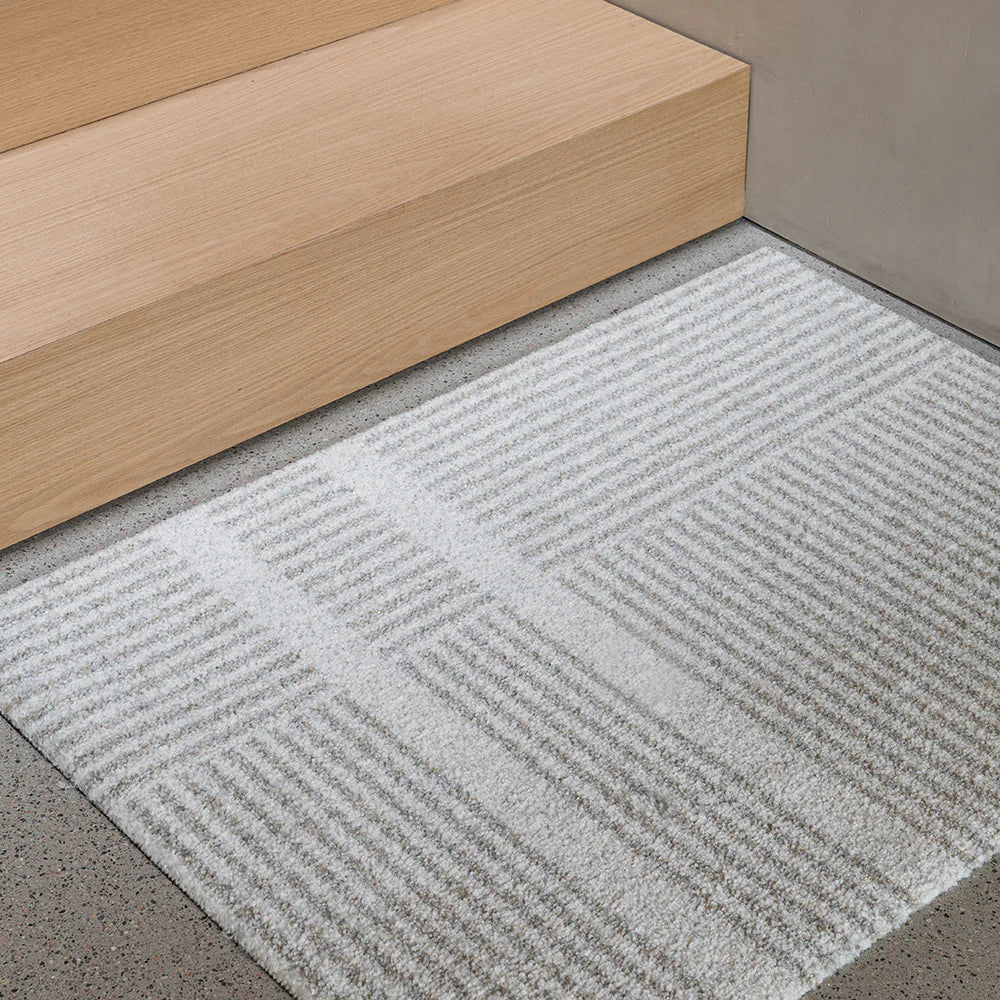 Heymat Løype Cloudy Grey mat, washable and slip-resistant, modern entryway rug. Styled in a Scandinavian stairway.