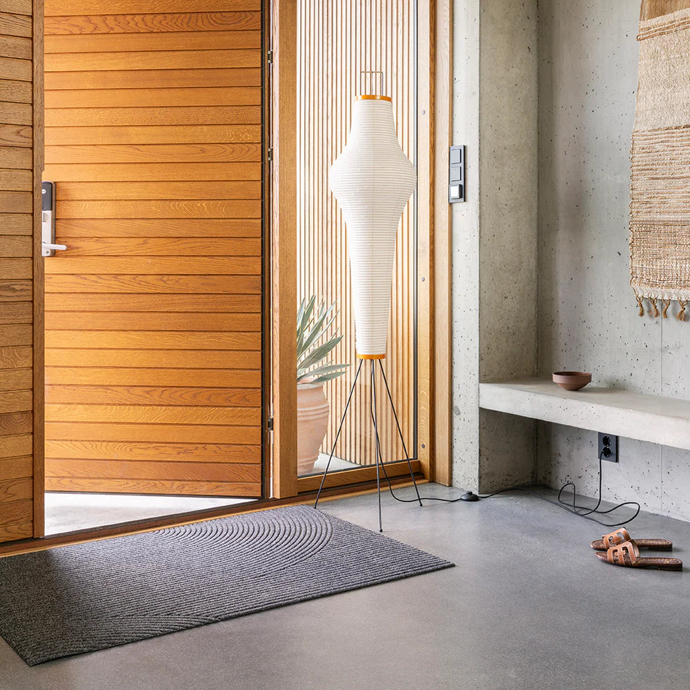 Heymat Stein outdoor doormat with stone-inspired pattern, recycled PET surface, non-slip rubber backing. Styled in modern entryway.