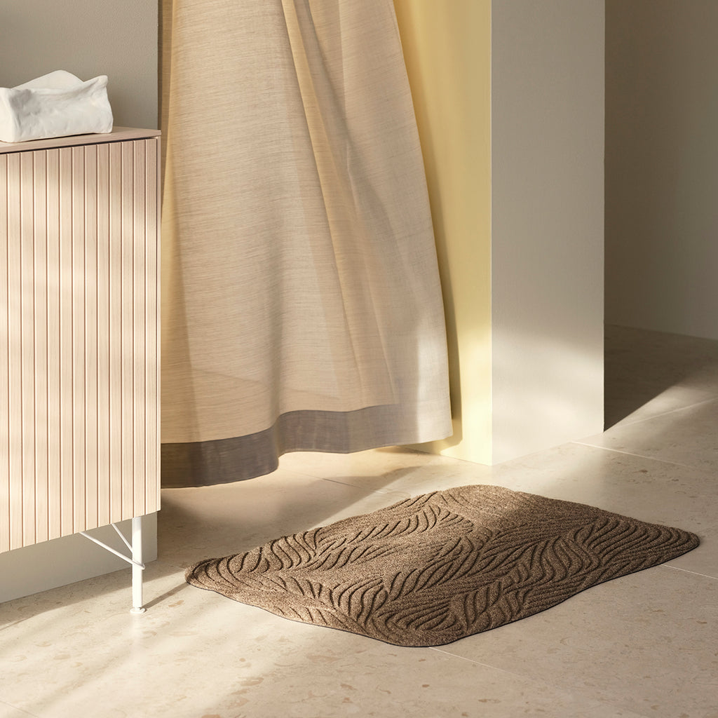 Eco-friendly beige Heymat Twine doormat with organic woven pattern, styled in a bright Scandinavian interior