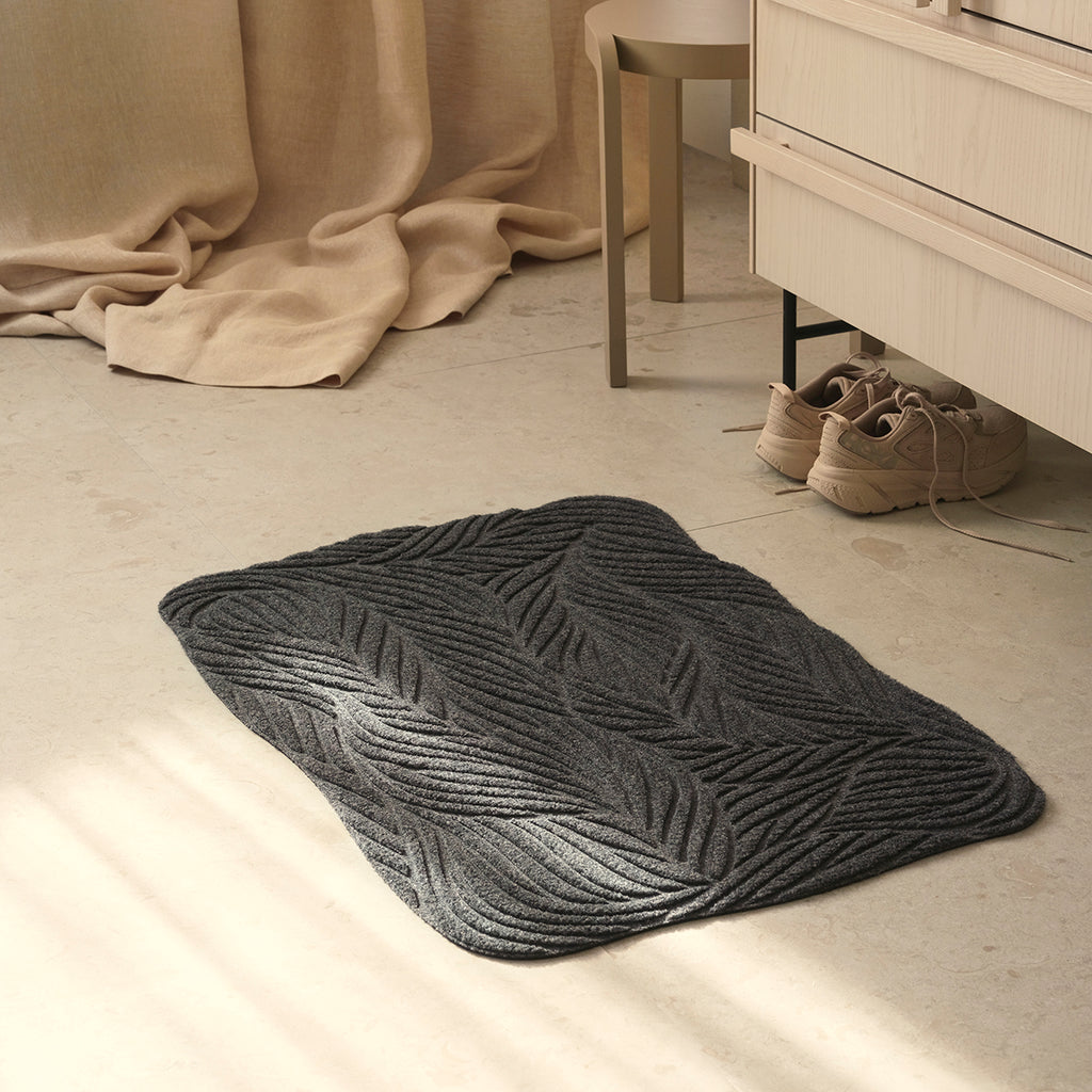 Eco-friendly green Heymat Twine doormat with organic woven pattern, styled in soft tone Scandinavian bedroom