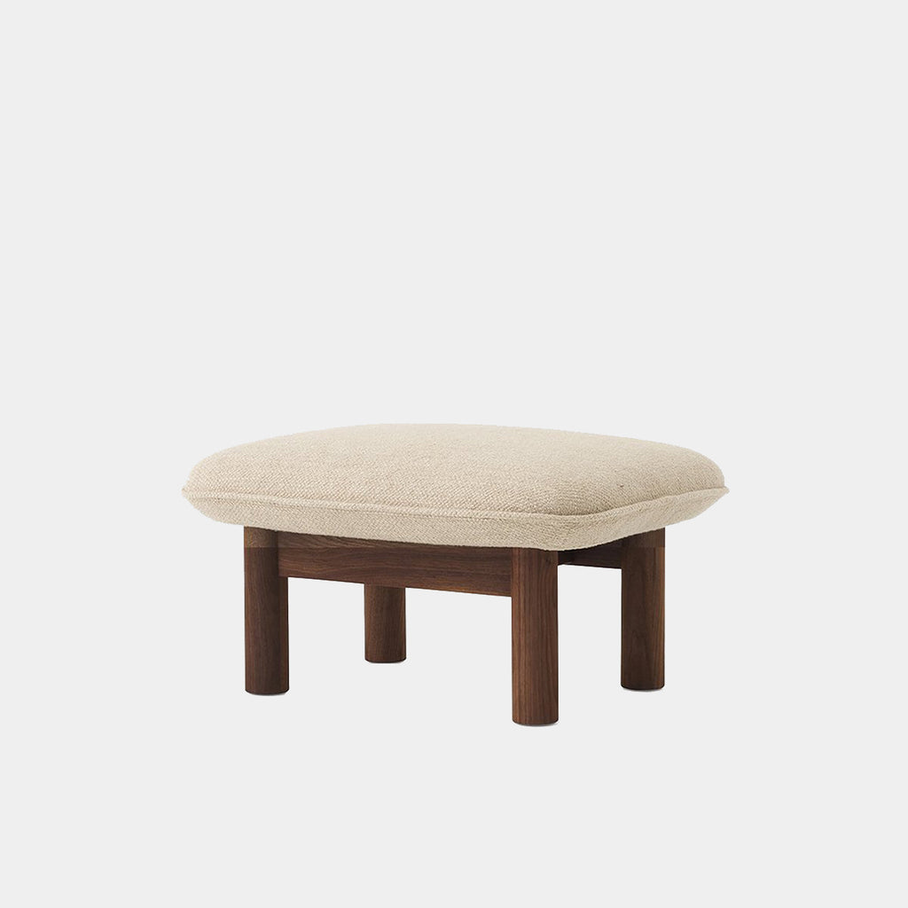 Audo Copenhagen Brasilia Ottoman in walnut with soft 02 Menu Bouclé upholstery, shown on a neutral background.