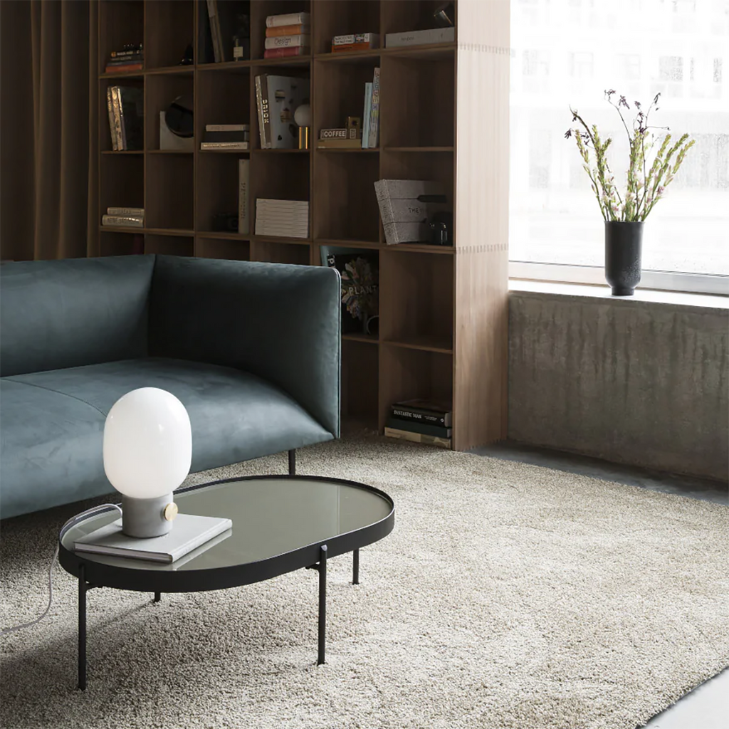 Audo Copenhagen NoNo Tables in assorted colors styled in a contemporary living space, highlighting their reflective glass tops and airy structure.