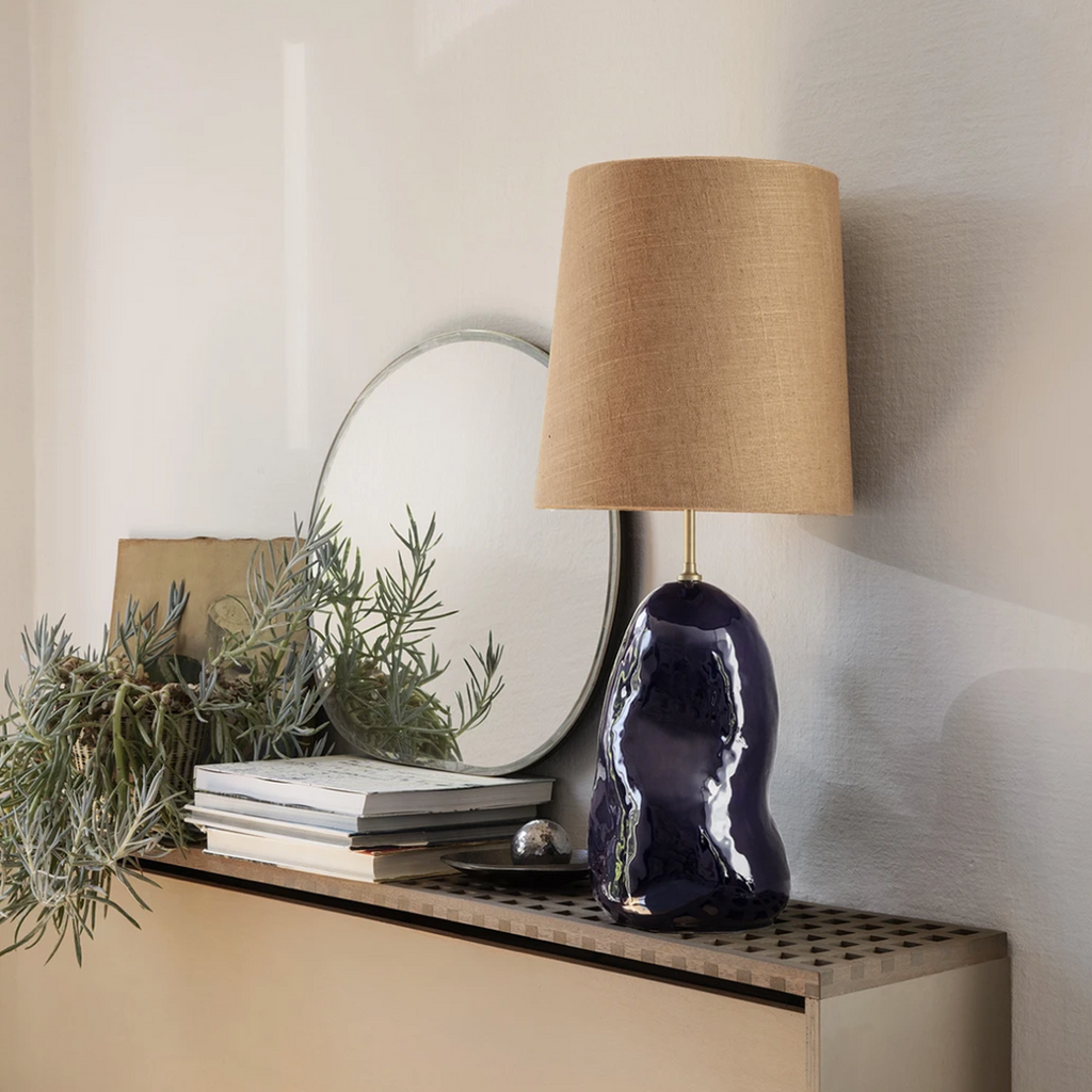 Pond Mirror Small in dark chrome styled above a sideboard with minimal décor and soft reflections of light.