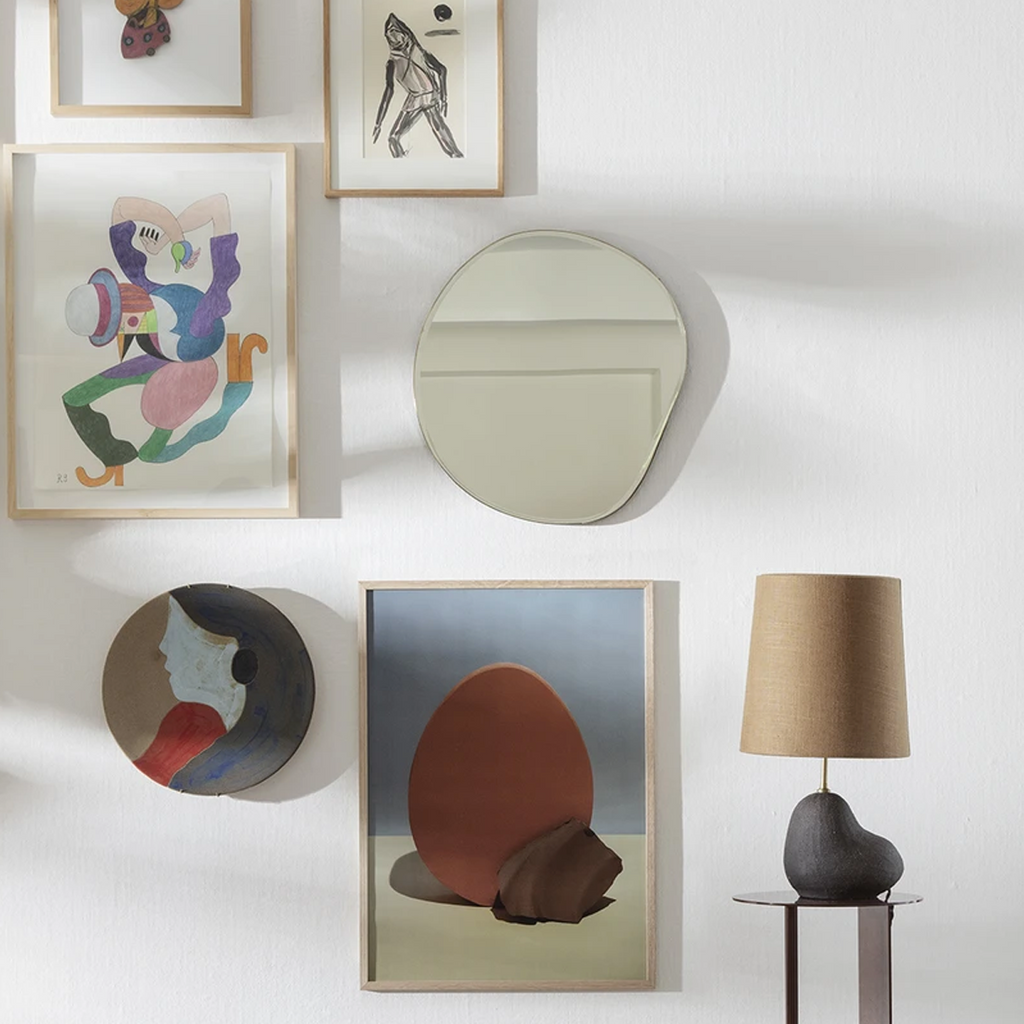 Pond Mirror by Ferm Living in size small shown styled within a gallery wall of modern art