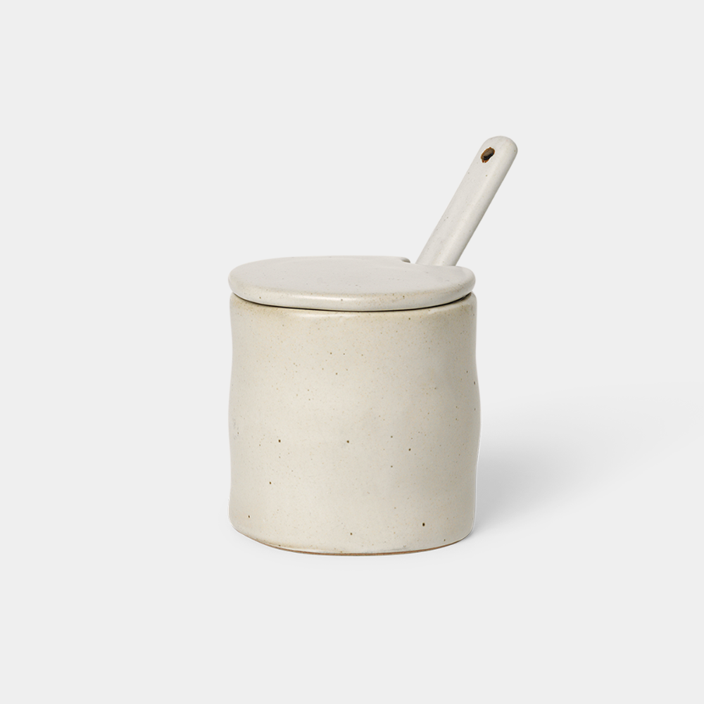 Flow Jam Jar with Spoon in Off-White Speckle glazed porcelain, shown with lid and spoon.