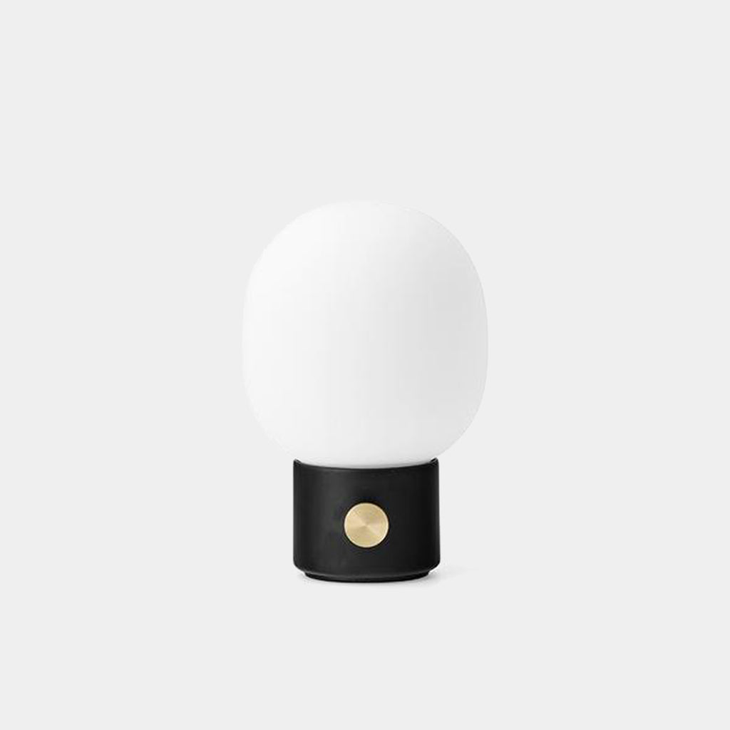 Audo Copenhagen JWDA Portable Lamp in black with frosted glass shade and brass dimmer, shown on a neutral background.