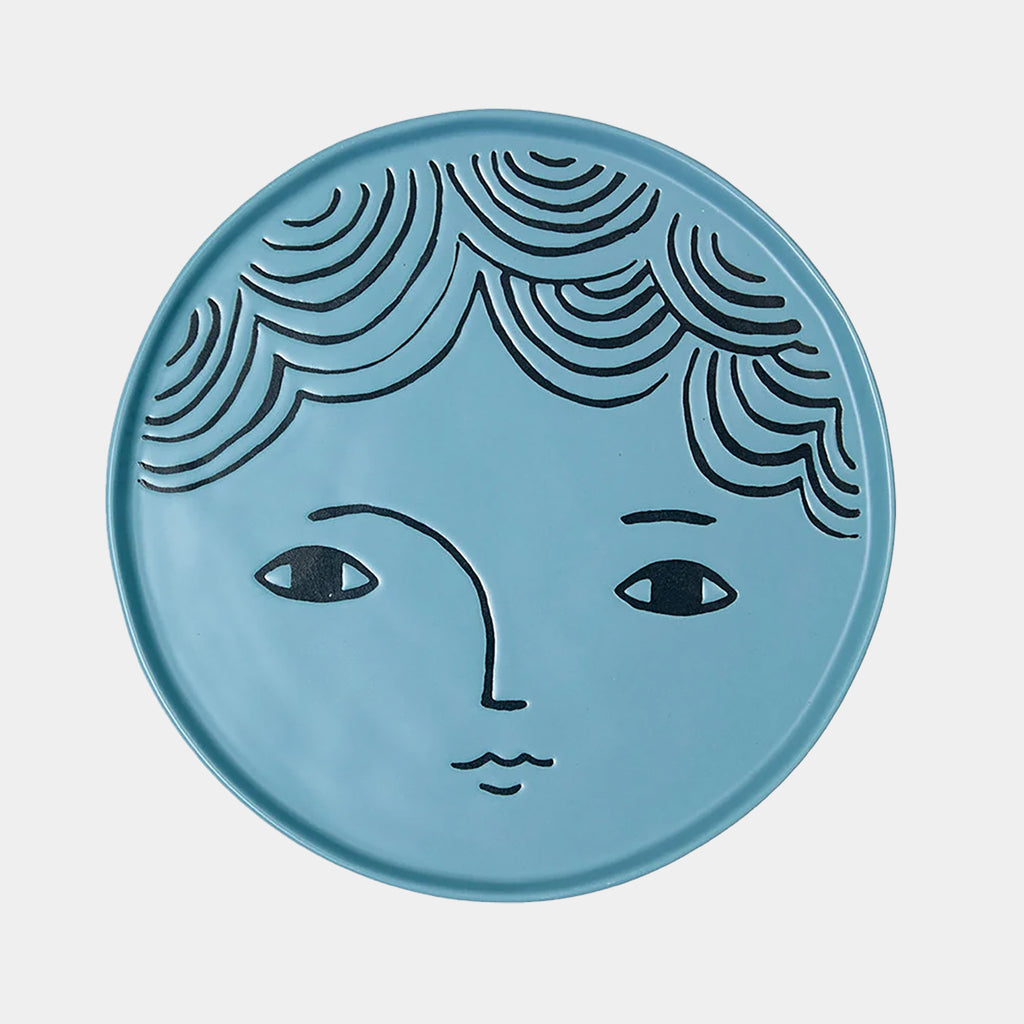 Donna Wilson stoneware plate in blue with illustrated face design.