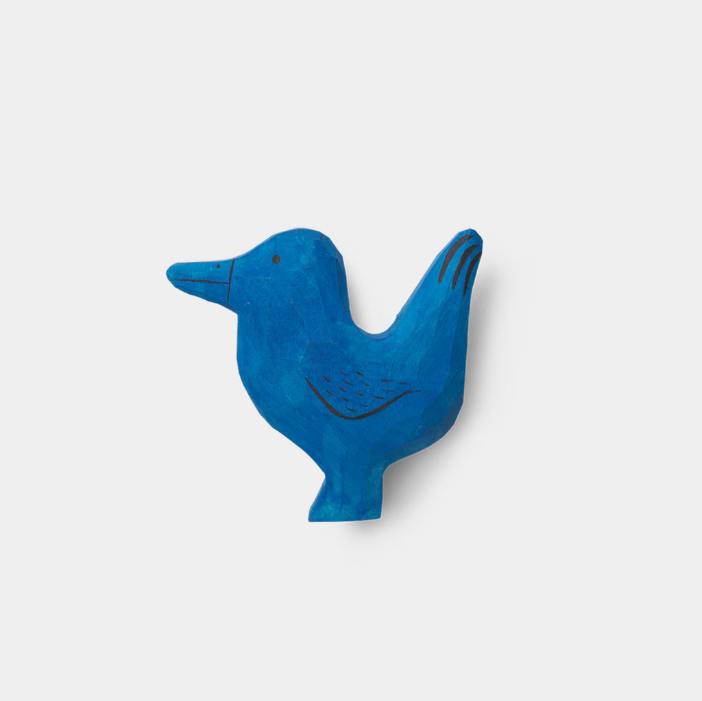 Ferm Living Anton Bird Hook — hand-carved wooden wall hook in the shape of a perched bird, painted in bright blue with engraved feather details.
