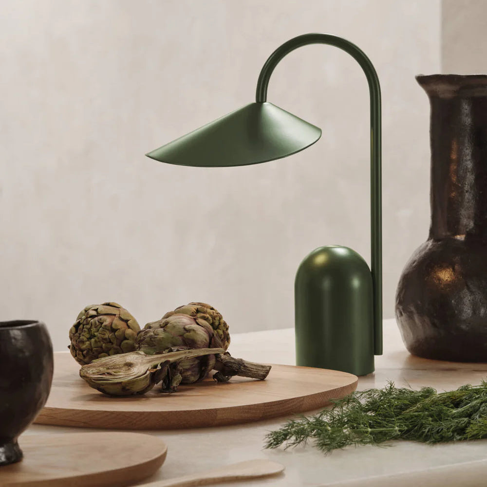 Green Grass Ferm Living Arum Portable Lamp in a lifestyle setting on a stone table with rustic kitchen accessories.