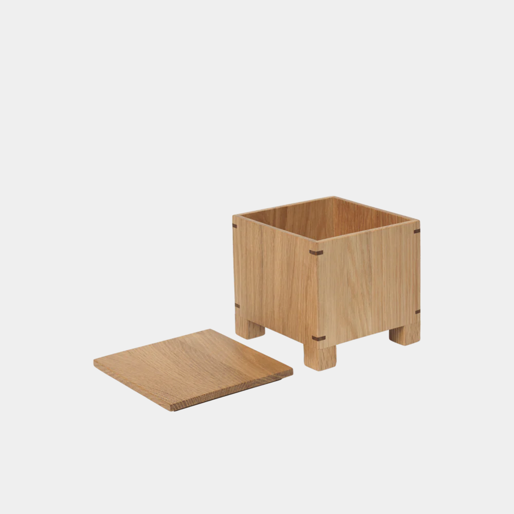 Ferm Living Bon Garlic Box in natural oak solid wood with square form and corner joints shown with lid open.