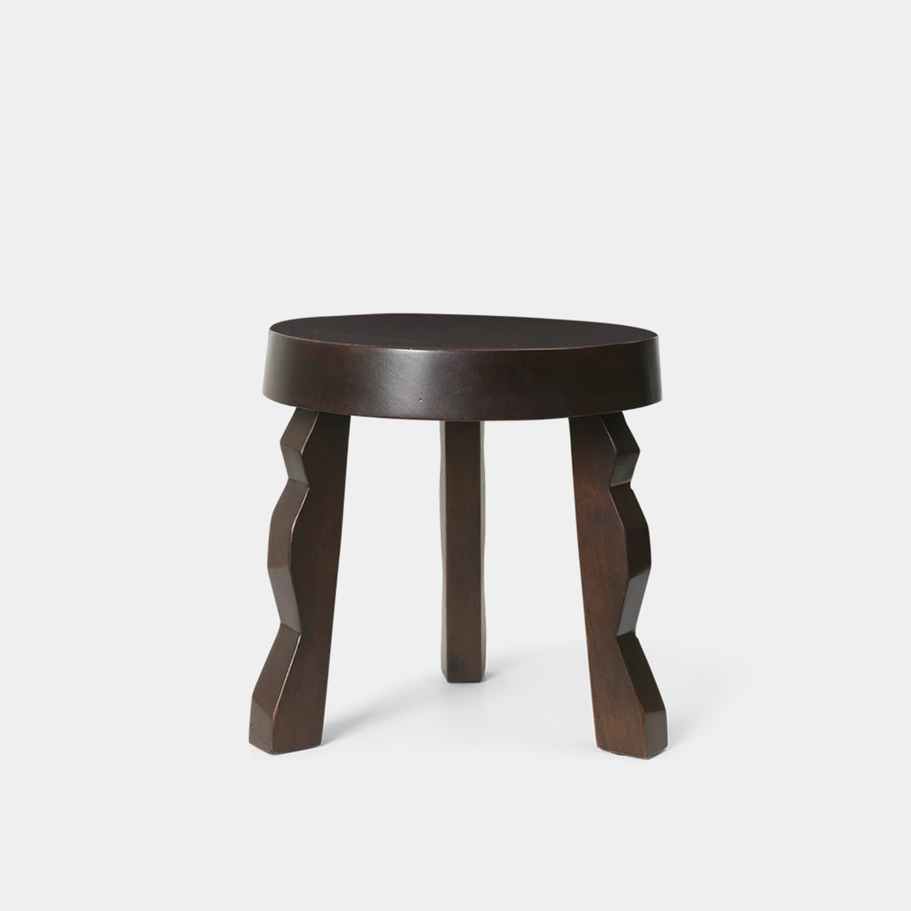 Ferm Living Faye Stool in dark brown mango wood with sculptural rippled legs and rounded seat