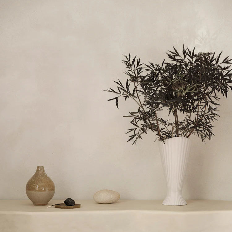 Fountain Vase with seasonal flowers, soft pleats casting gentle shadows