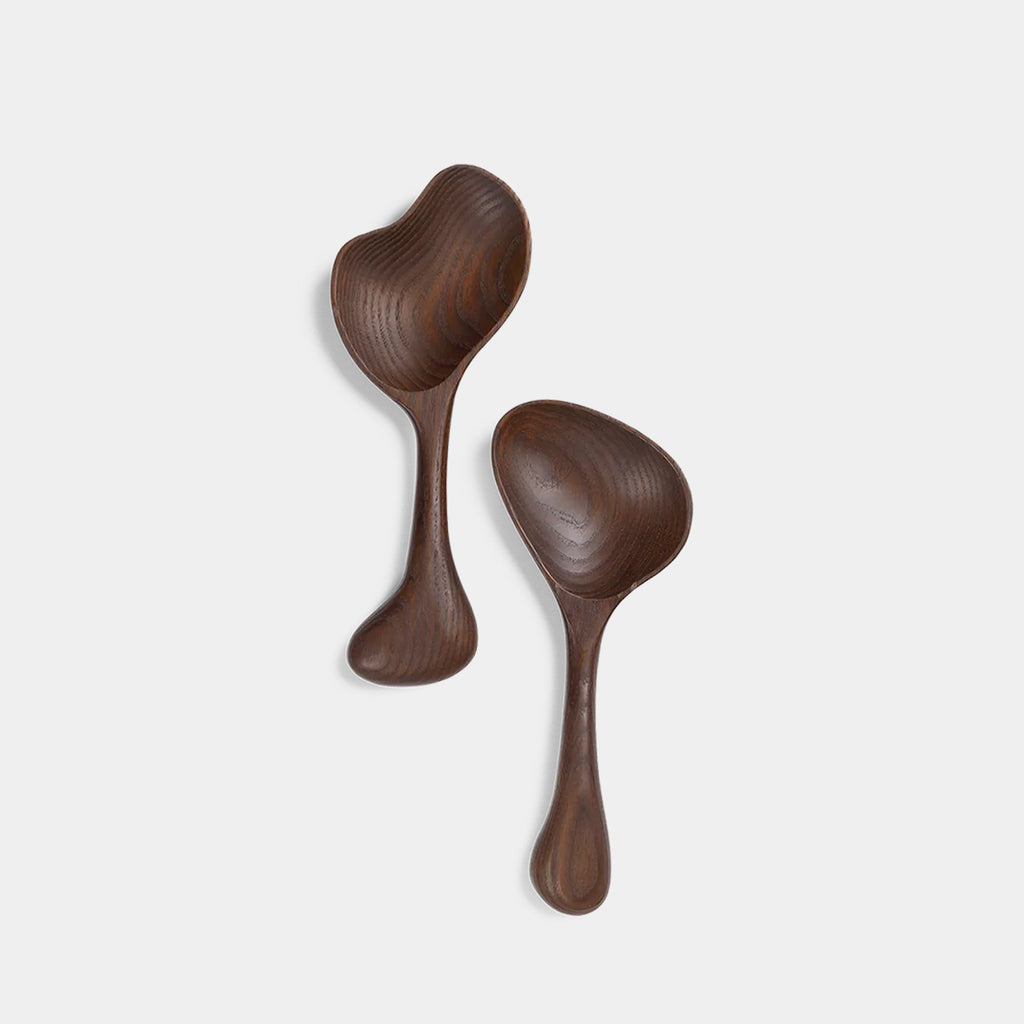 Ferm Living Os Salad Servers featuring bone-inspired curved forms in carbonised ash wood on neutral background