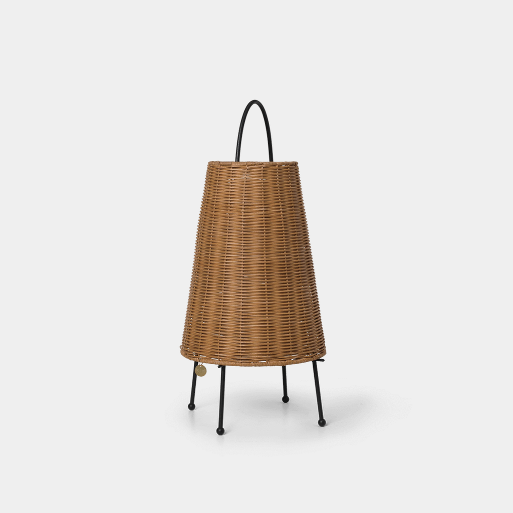 Braided rattan portable table lamp with slender metal base on a neutral background, showing texture and woven rattan detail