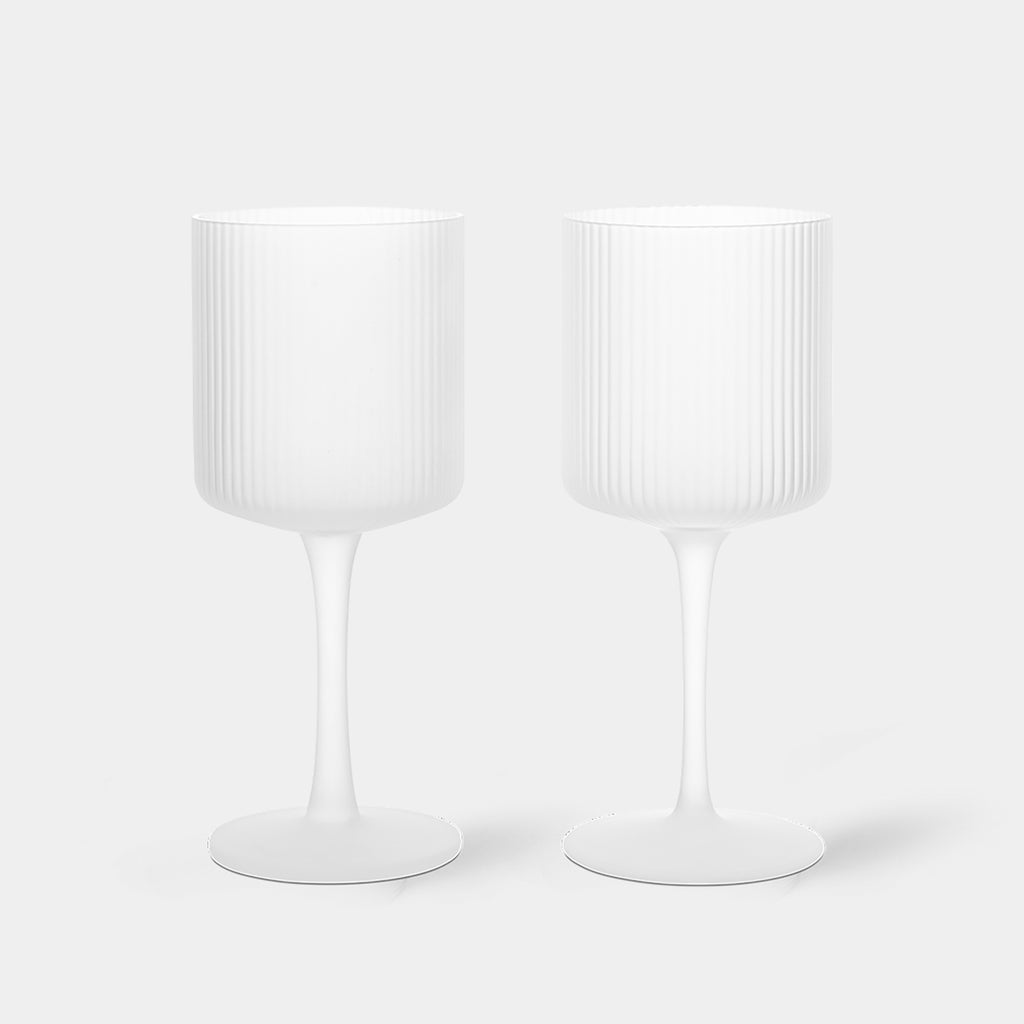 Fluted Ripple white wine glasses by Ferm Living featuring frosted clear mouth-blown glass and a vertically ribbed surface that catches and reflects light beautifully