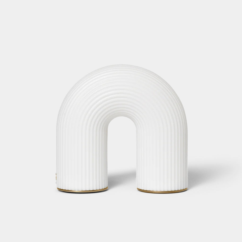 Ferm Living Vuelta Portable Lamp in White with sculptural arched form and brass feet