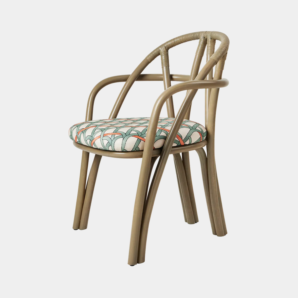 GUBI Bistra Dining Armchair with Reales  001 upholstered seat and steam-bent rattan frame on a neutral background
