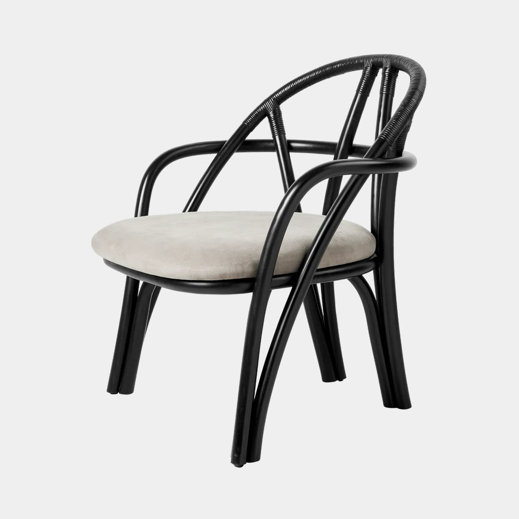 GUBI Bistra Lounge Chair with upholstered seat and steam-bent Ebony Painted rattan frame on a neutral background