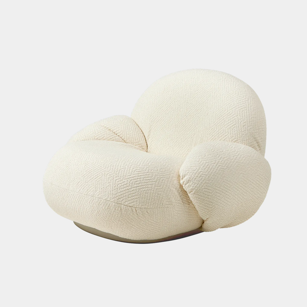 Angled view of the Pacha lounge chair in Dora Boucle, highlighting its soft curves and low, lounge-style profile