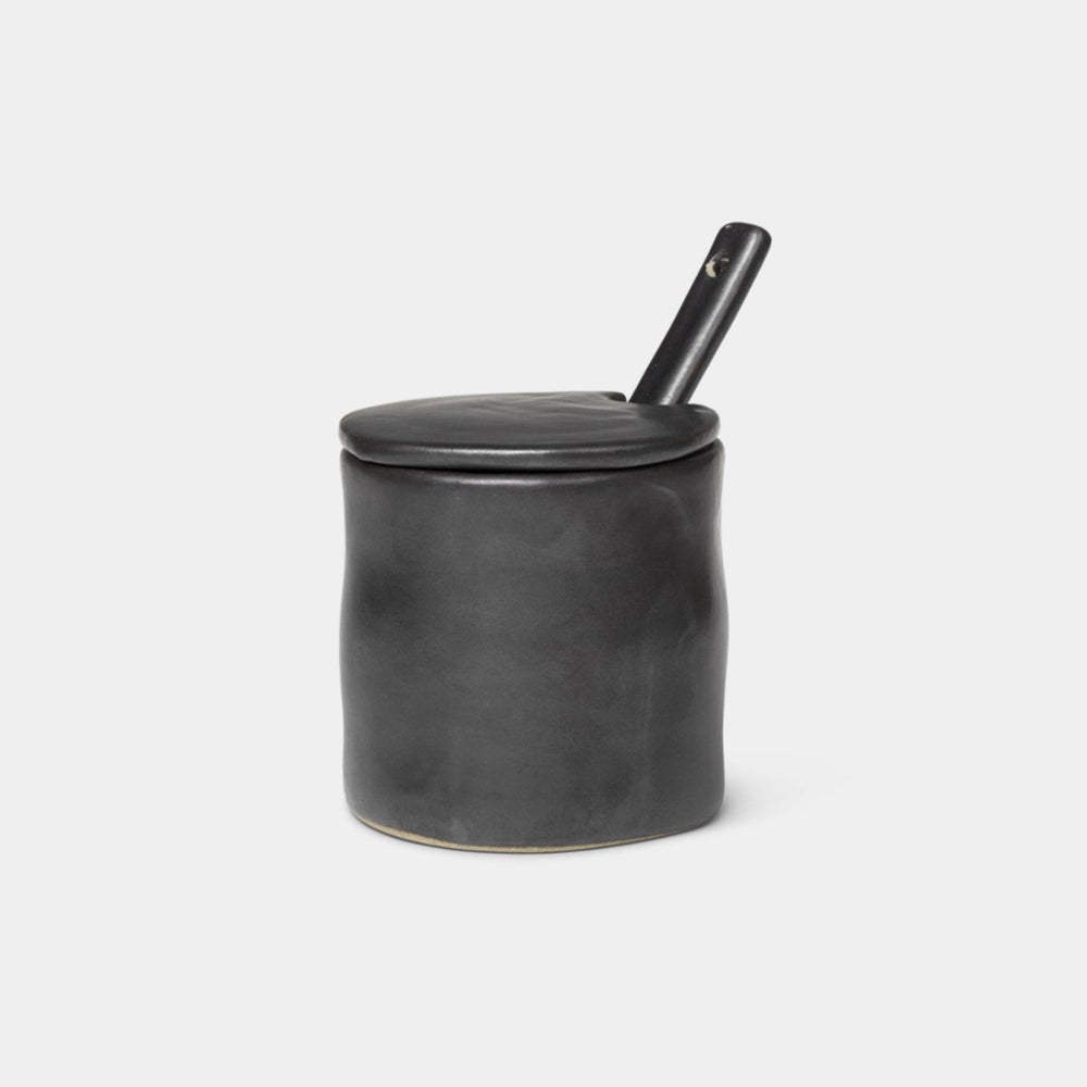 Flow Jam Jar with Spoon in Black glazed porcelain, shown with lid and stainless steel spoon.