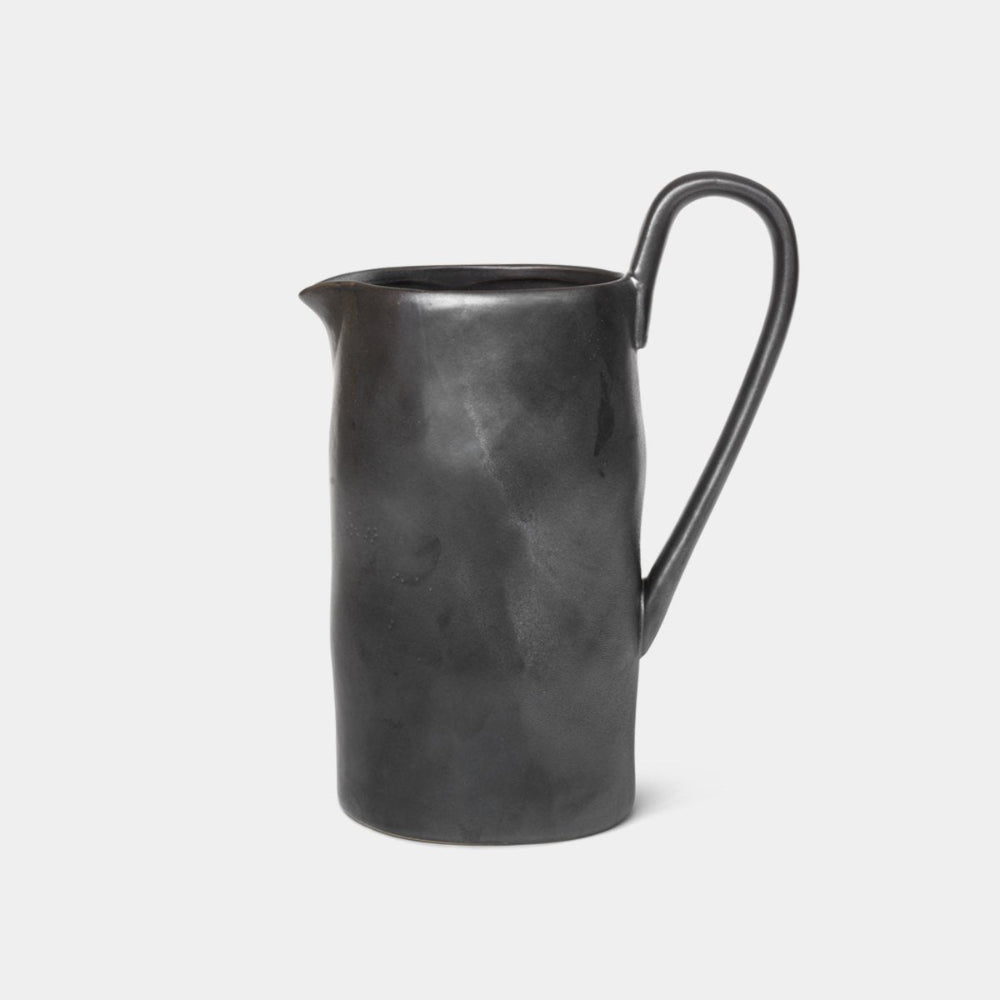 Ferm Living Flow Jug in Black — semi-matte glazed porcelain jug with curved handle and organic silhouette.