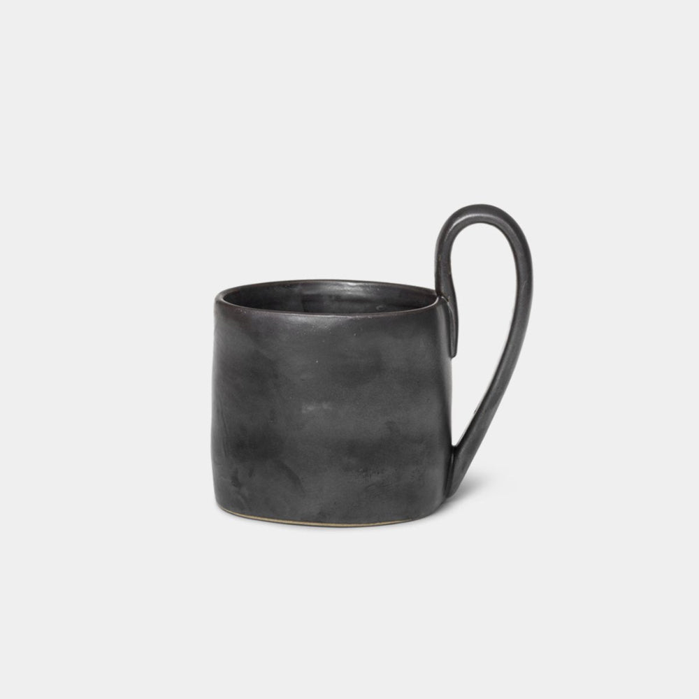 Ferm Living Flow Mug in Black — semi-matte porcelain mug with organic shape and curved handle.