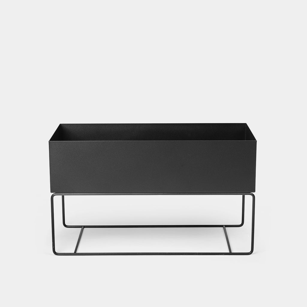 Ferm Living Large Plant Box in black powder-coated steel shown on a light background, designed for use as a planter, storage bench, or decorative organizer in modern interiors.