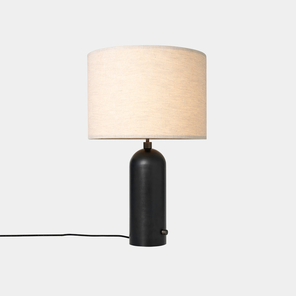 Gravity Table Lamp in Blackened Steel with Canvas shade on neutral background