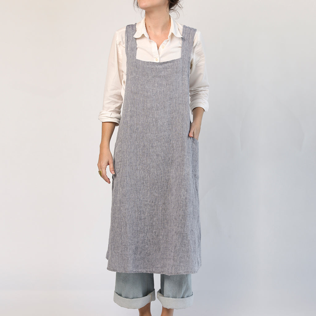 Japanese Apron by Linge Particulier in chambray with crossed-back straps and two side pockets, displayed on model